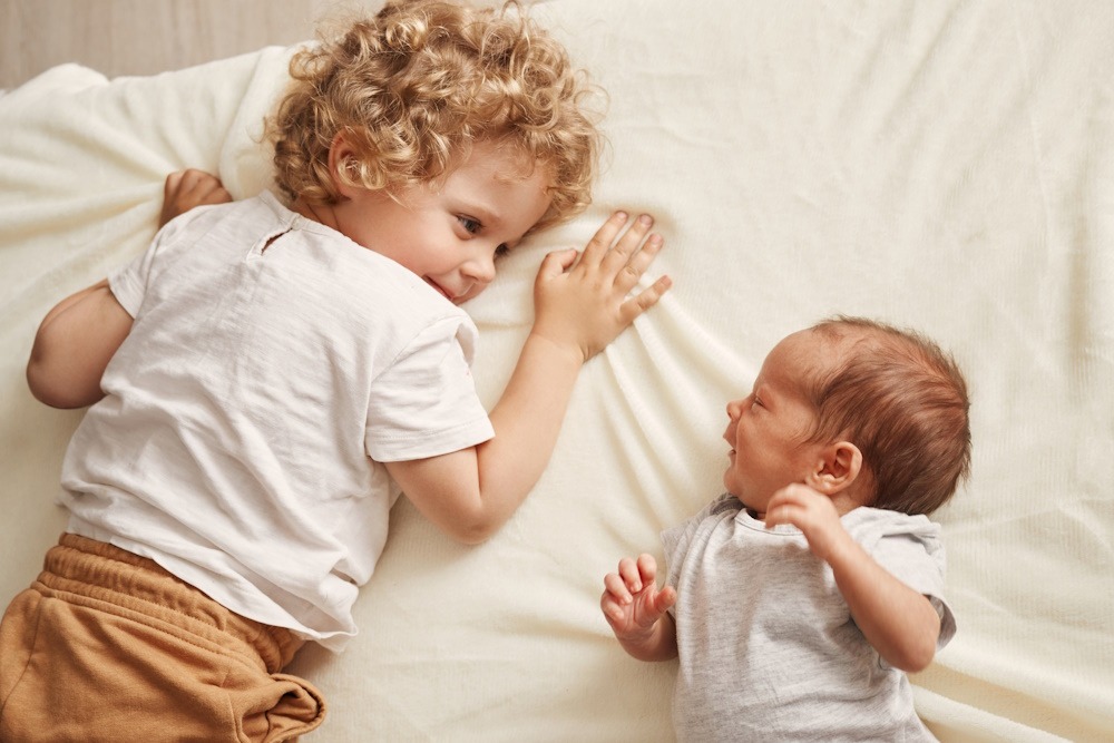 Sfeerbeeld van een kind en een baby samen ter illustratie op de pagina om samen te werken met cadeausvoorkids.com